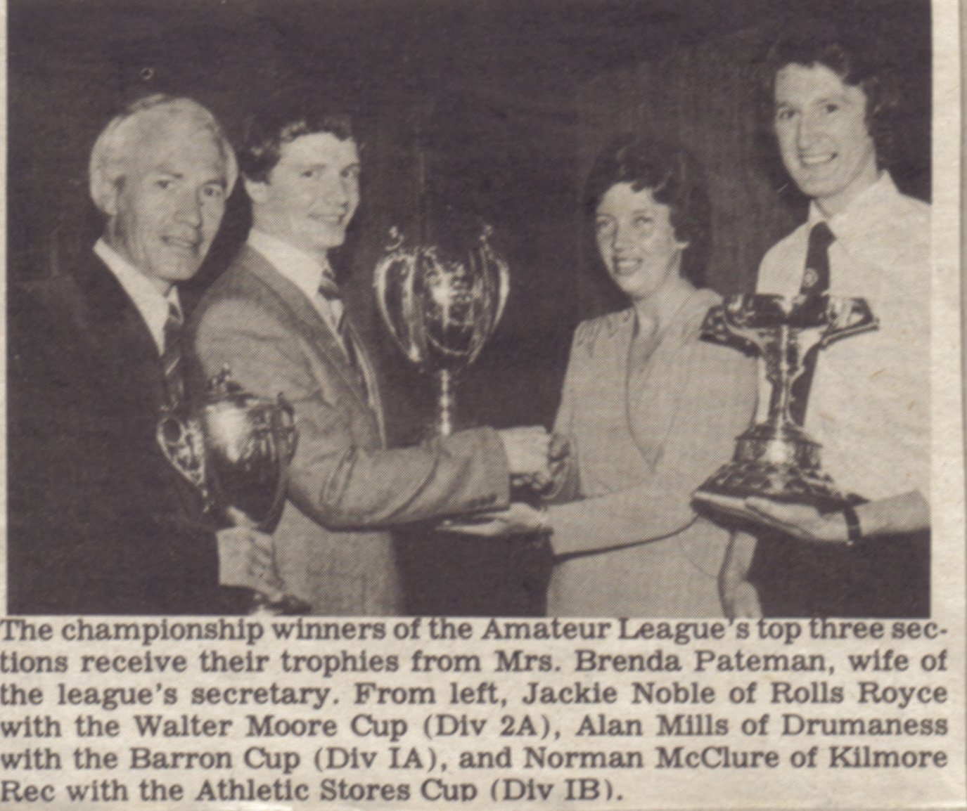 Norman McClure, right, collects the Athletic Stores Cup as Division 1B champions, from Brenda Pateman, wife of the league secretary. Alongside him, Jackie Noble of Rolls Royce and Alan Mills of Drumaness with the other two championship trophies.